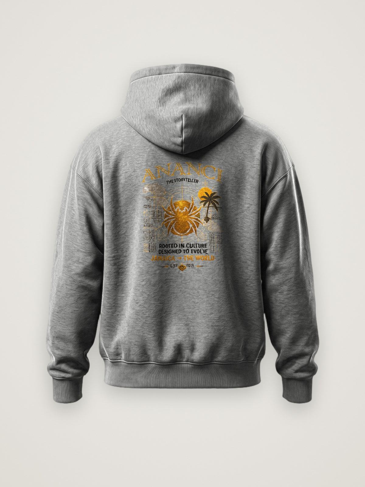 Back of the heather grey ANANCI The Storyteller Hoodie with the The Storyteller graphic with gold spider, island map, palm and Jamaica to the world lettering