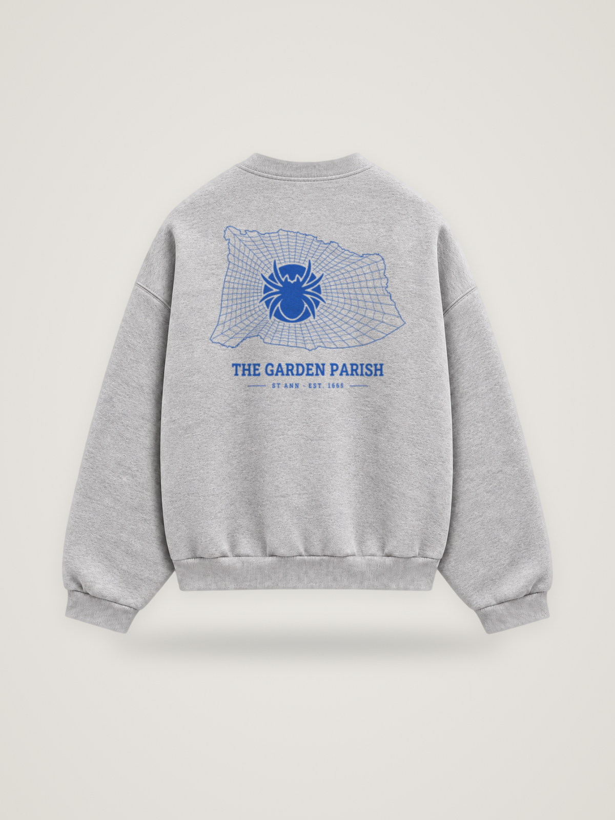 Back of the heather grey ANANCI Where Yuh From? St Ann crewneck with the St Ann map, web and spider in cobalt ink, “THE GARDEN PARISH” and ST ANN · EST. 1665
