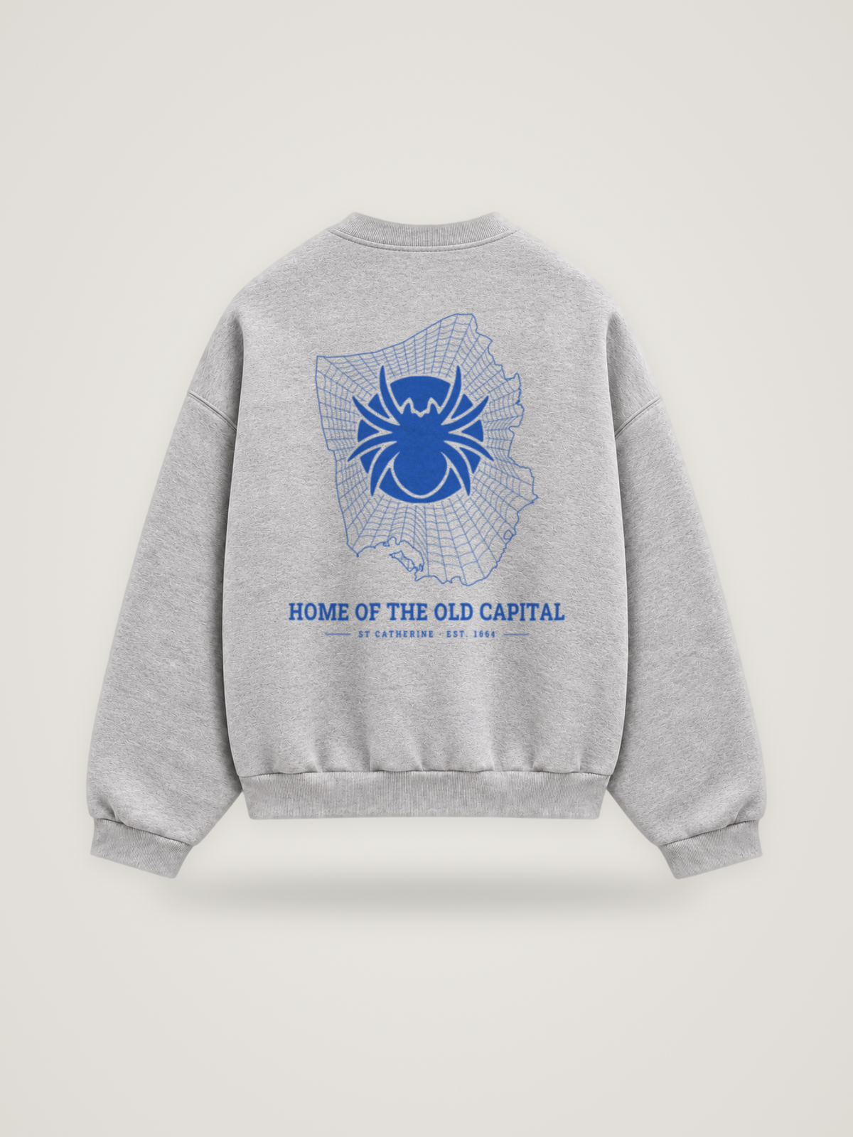 Back of the heather grey ANANCI Where Yuh From? St Catherine crewneck with the St Catherine map, web and spider in cobalt ink, “HOME OF THE OLD CAPITAL” and ST CATHERINE · EST. 1664