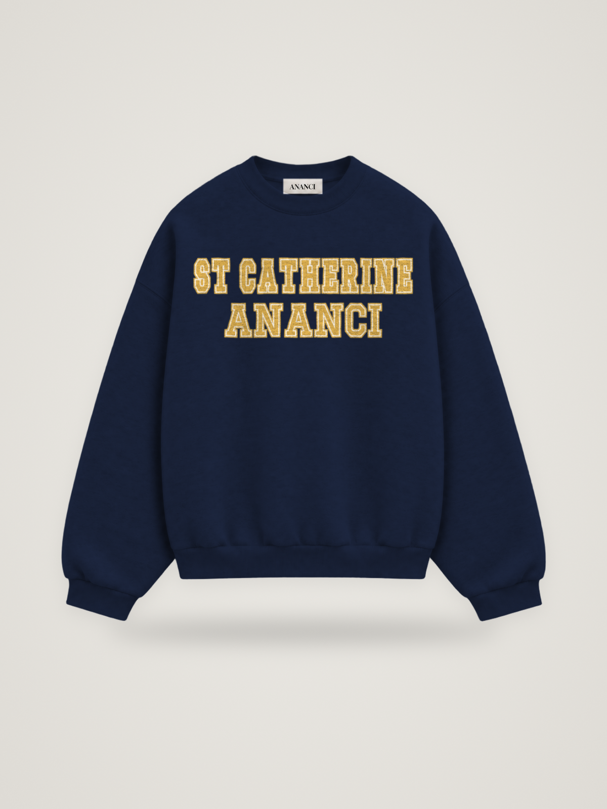 Front of the midnight ANANCI Where Yuh From? St Catherine crewneck with straight two-tone varsity lettering, gold with a cream inline, reading ST CATHERINE over ANANCI