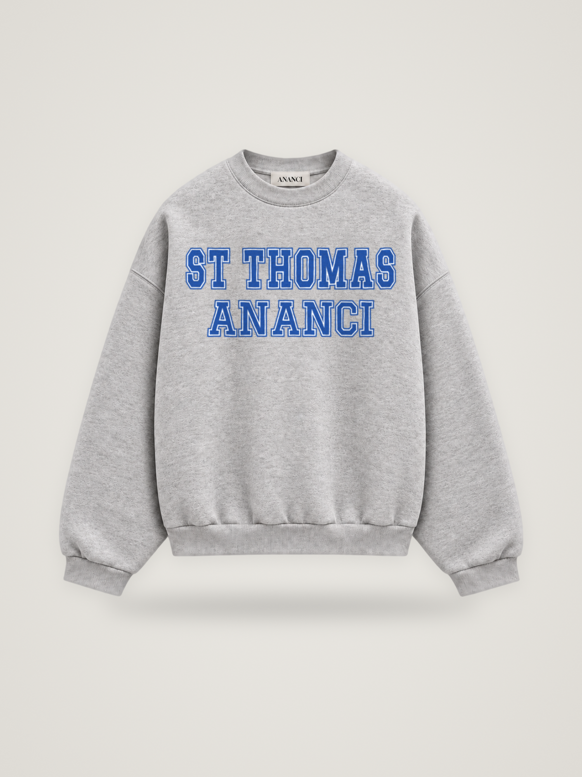 Front of the heather grey ANANCI Where Yuh From? St Thomas crewneck with straight two-tone varsity lettering, cobalt with a white inline, reading ST THOMAS over ANANCI