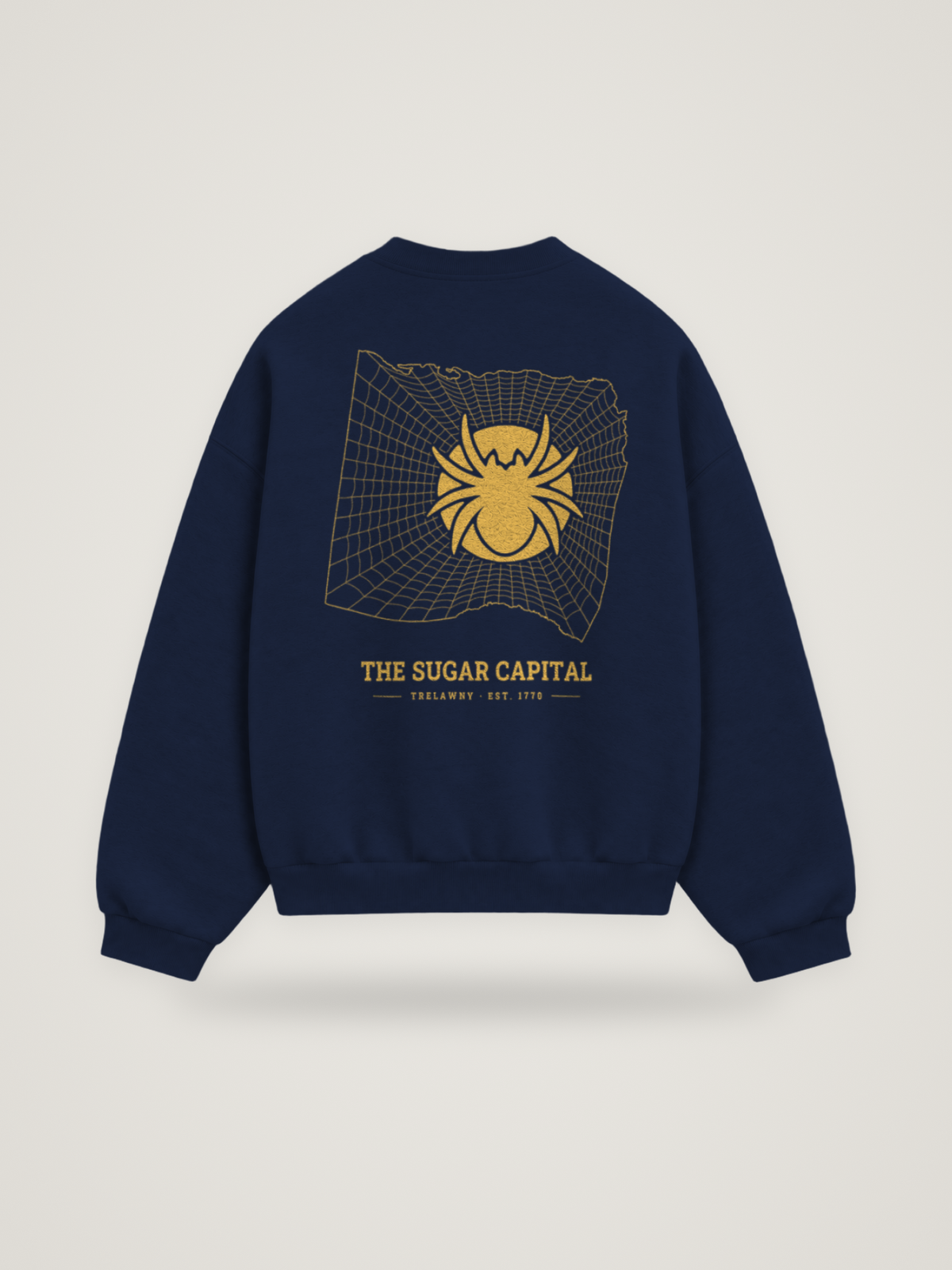 Back of the midnight ANANCI Where Yuh From? Trelawny crewneck with the Trelawny map, web and spider in gold ink, “THE SUGAR CAPITAL” and TRELAWNY · EST. 1770
