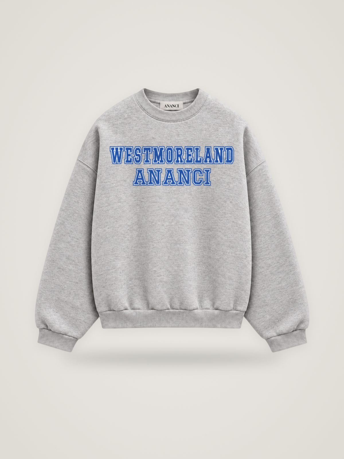 Front of the heather grey ANANCI Where Yuh From? Westmoreland crewneck with straight two-tone varsity lettering, cobalt with a white inline, reading WESTMORELAND over ANANCI