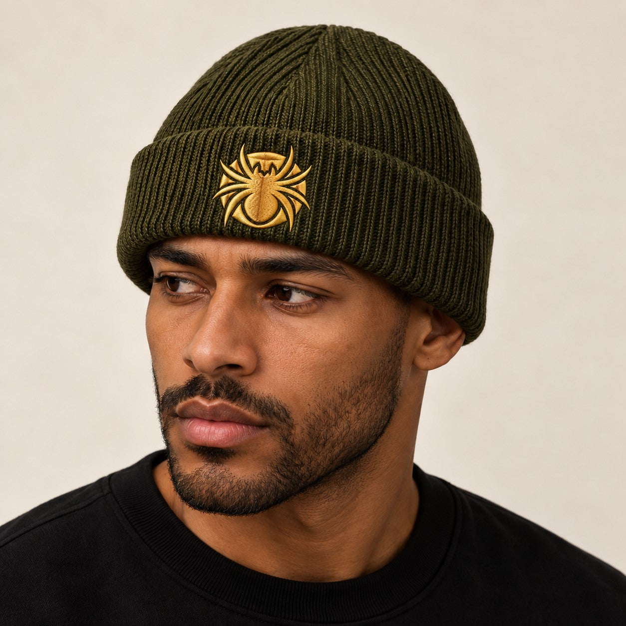 Ananci Signature Beanie in olive green with gold embroidered spider patch