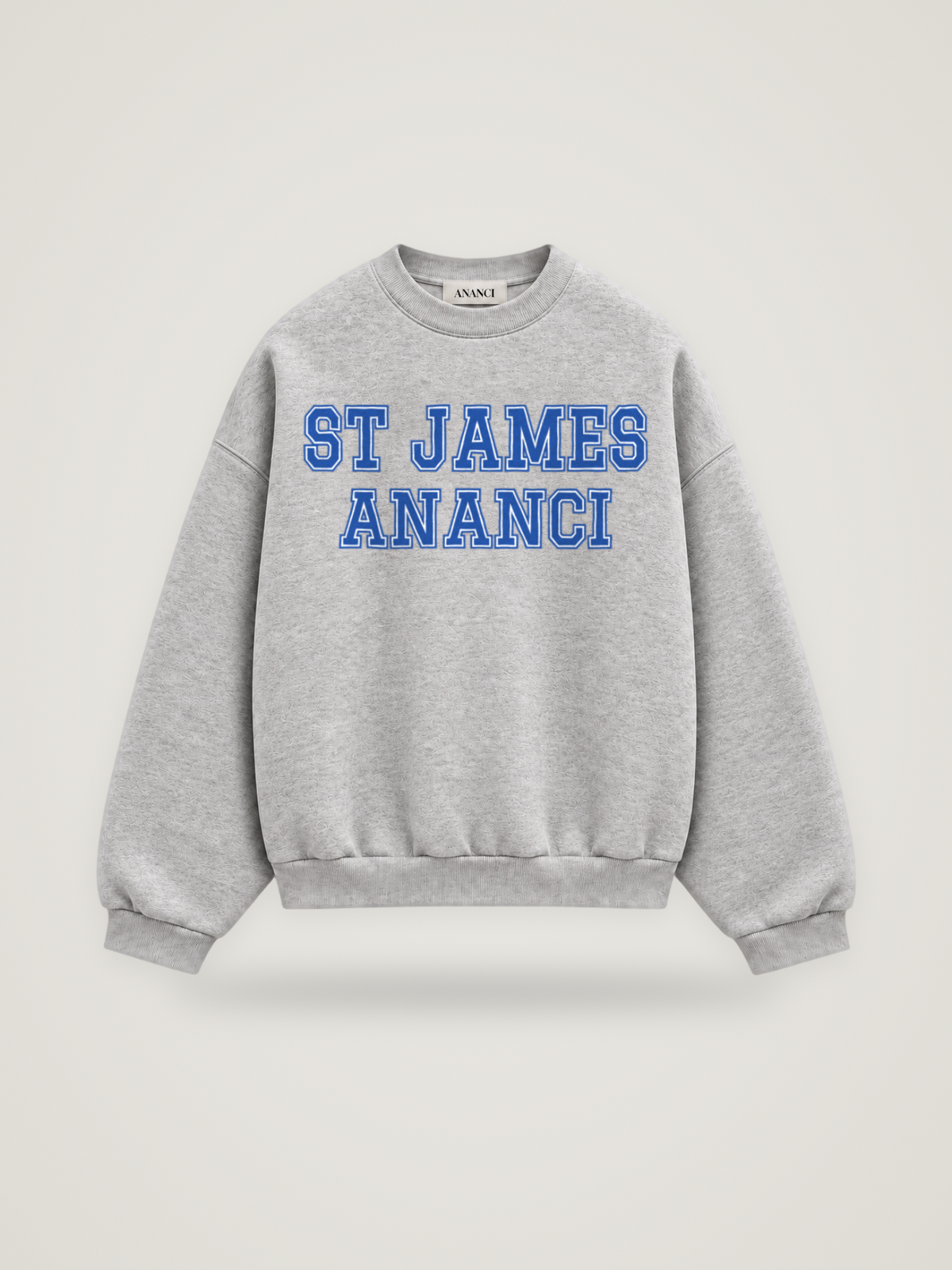 Front of the heather grey ANANCI Where Yuh From? St James crewneck with straight two-tone varsity lettering, cobalt with a white inline, reading ST JAMES over ANANCI