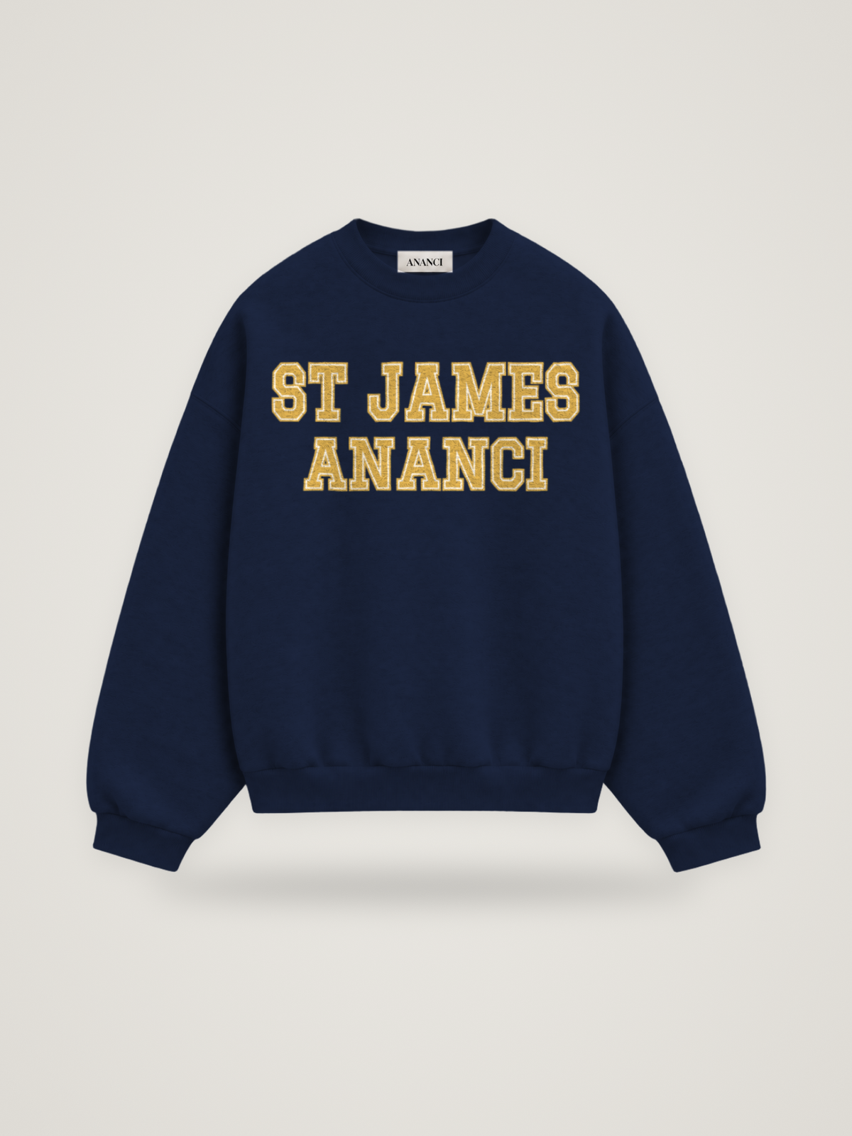 Front of the midnight ANANCI Where Yuh From? St James crewneck with straight two-tone varsity lettering, gold with a cream inline, reading ST JAMES over ANANCI