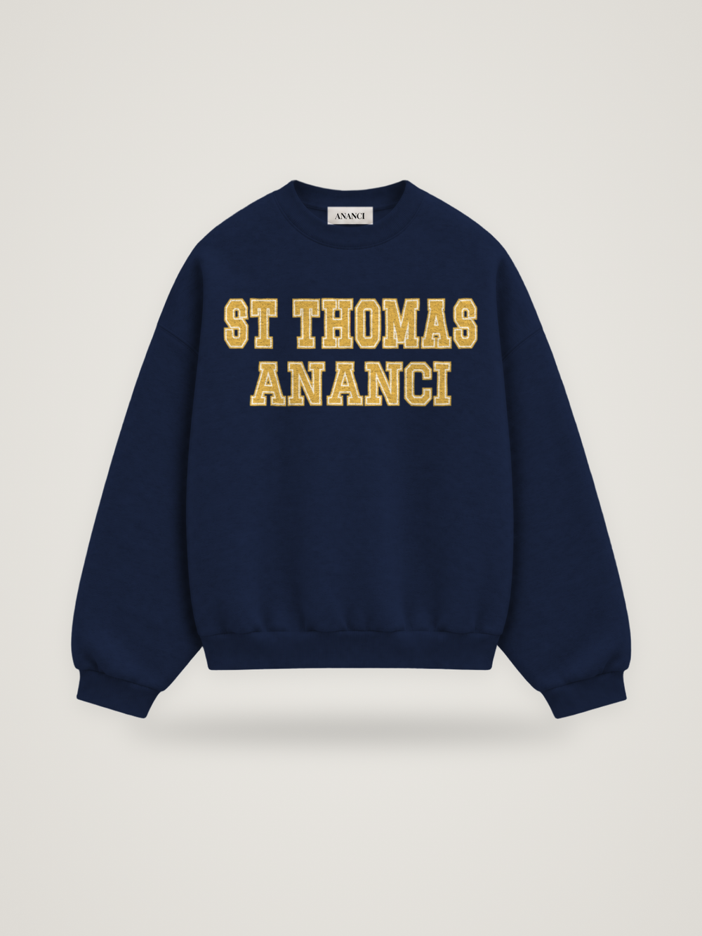 Front of the midnight ANANCI Where Yuh From? St Thomas crewneck with straight two-tone varsity lettering, gold with a cream inline, reading ST THOMAS over ANANCI
