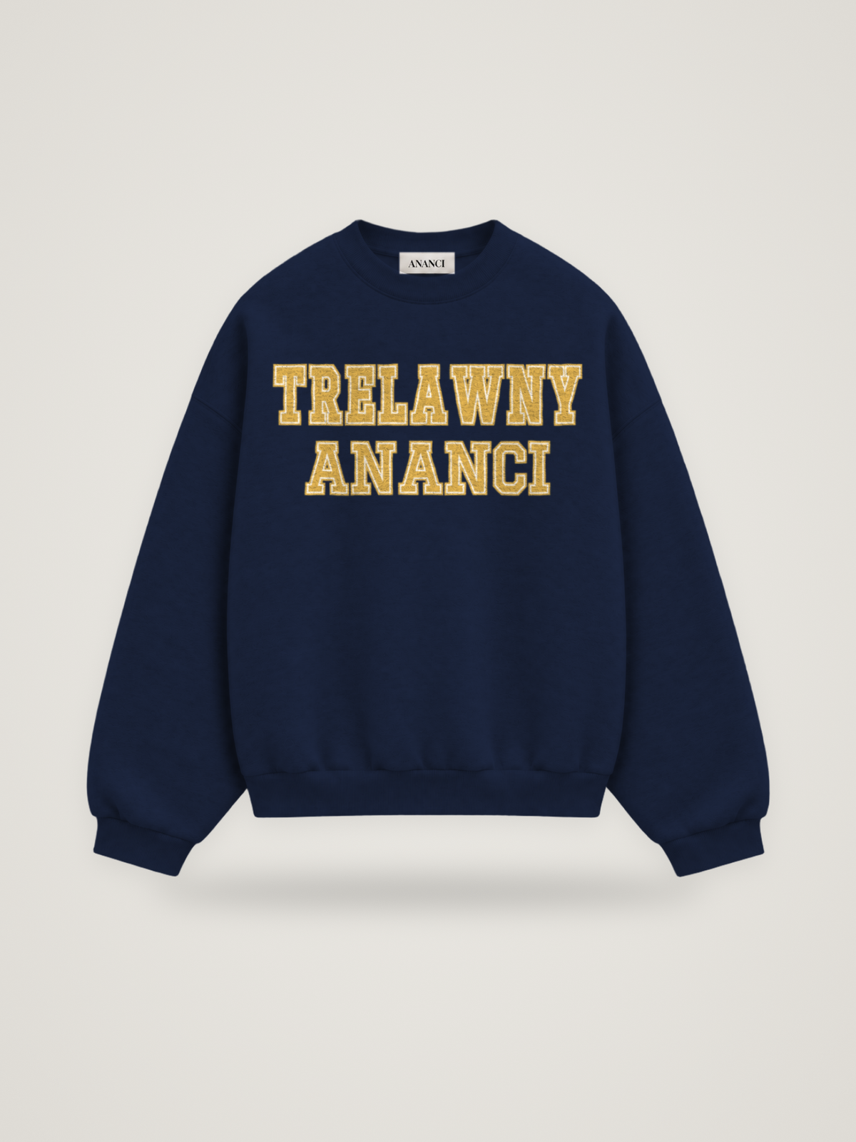 Front of the midnight ANANCI Where Yuh From? Trelawny crewneck with straight two-tone varsity lettering, gold with a cream inline, reading TRELAWNY over ANANCI