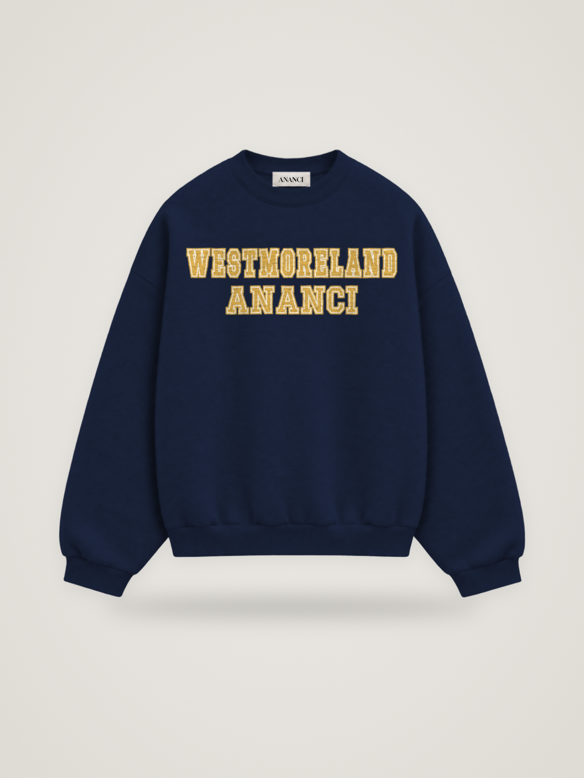 Front of the midnight ANANCI Where Yuh From? Westmoreland crewneck with straight two-tone varsity lettering, gold with a cream inline, reading WESTMORELAND over ANANCI