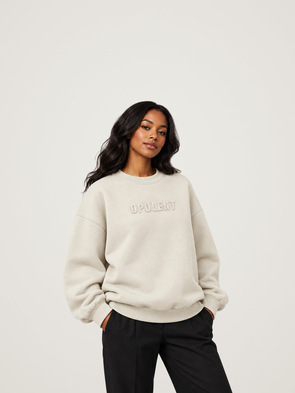 Woman wearing the cream ANANCI Opulent crewneck with tonal raised OPULENT lettering