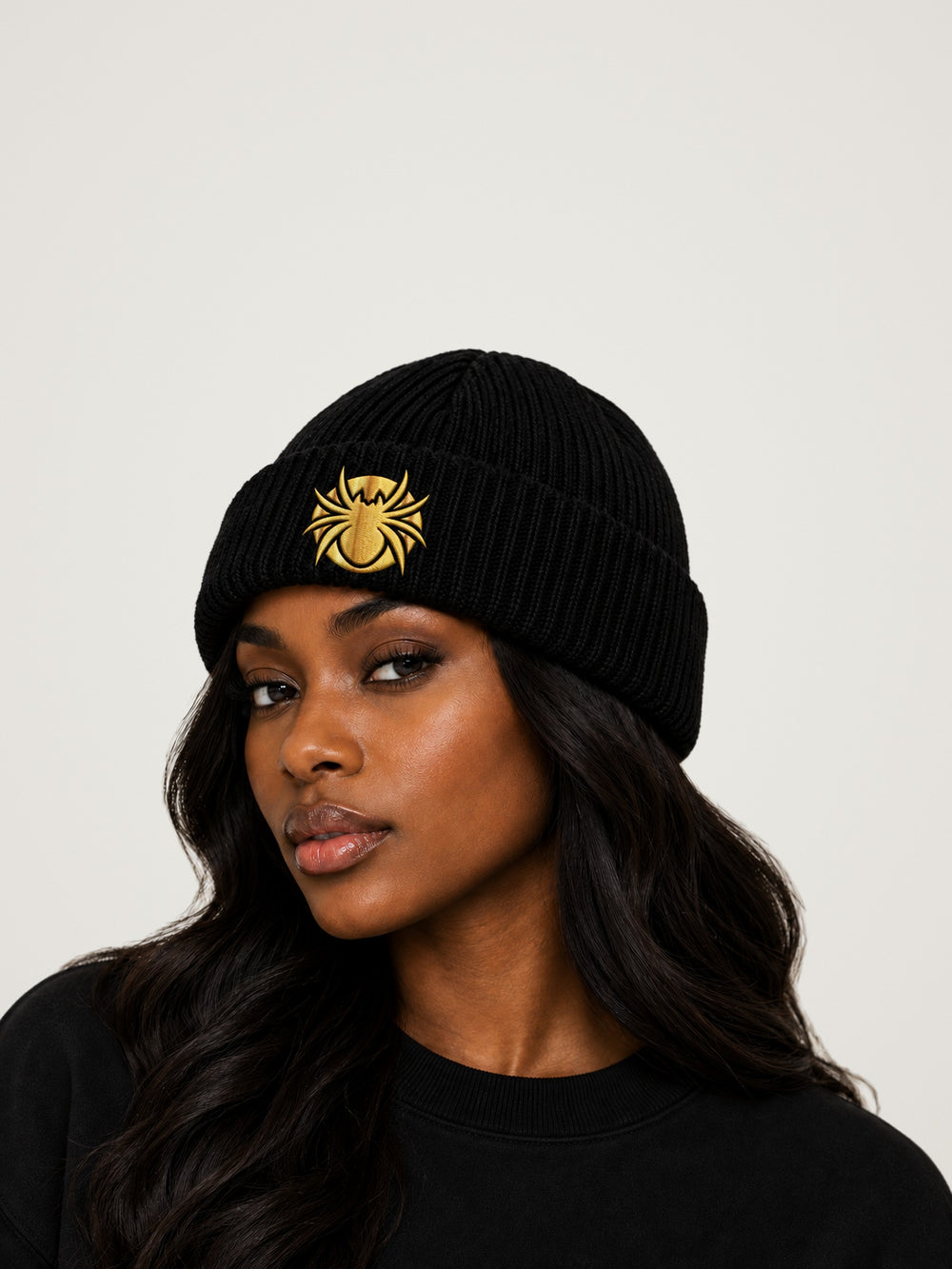 Ananci Signature Beanie in black with gold embroidered spider patch